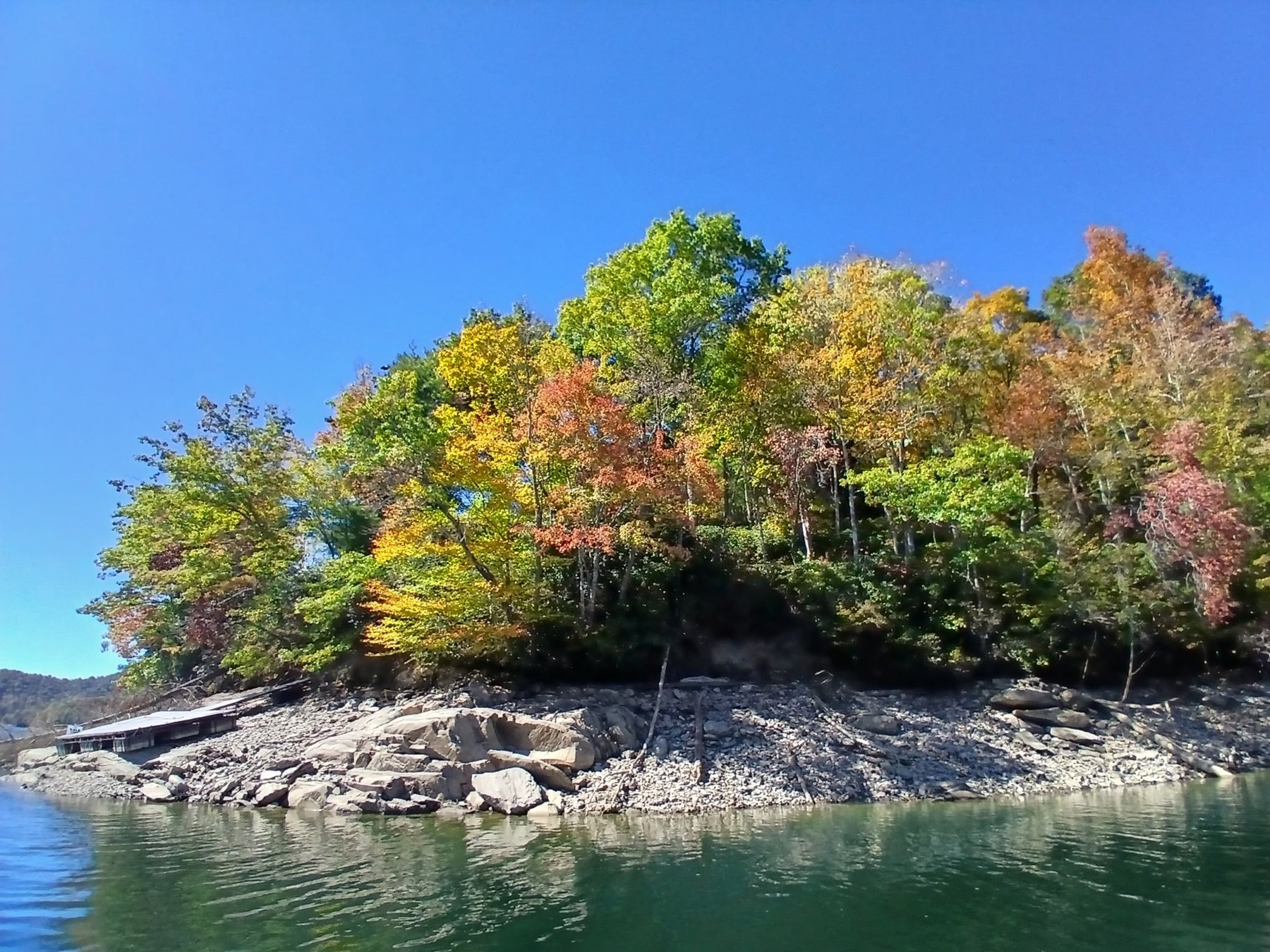 Nantahala Lake in autumn, fall foliage along the rocky shoreline